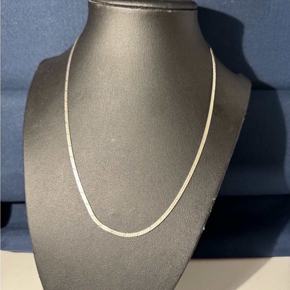 Silver necklace, herringbone flat chain with spring clasp closure.